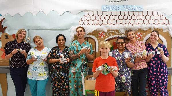 group of nurses in Christmas scrubs and a young boy with blonde hair