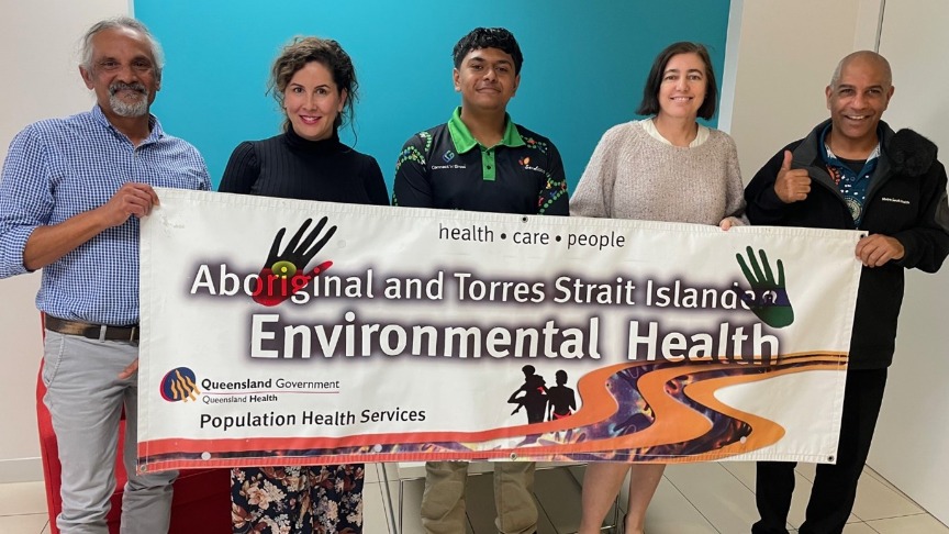 Public health staff holding up an Aboriginal and Torres Strait Islander banner