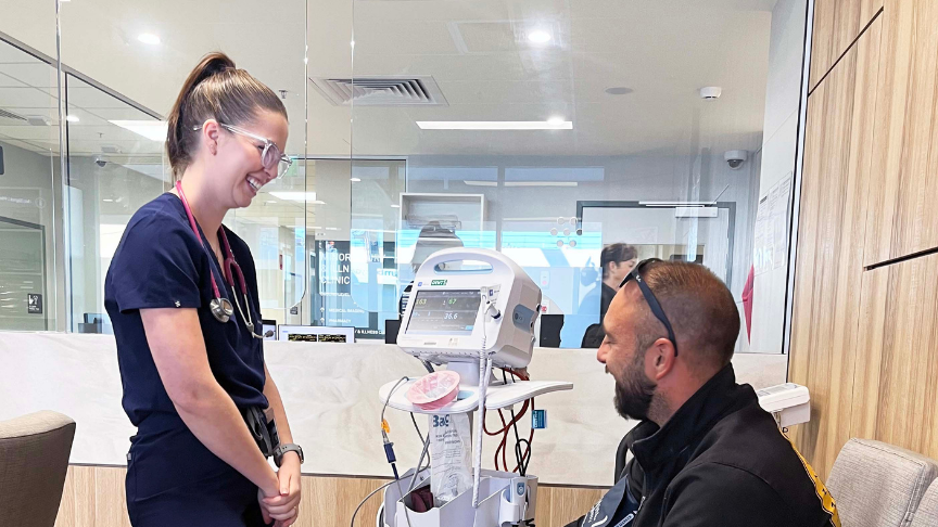 Female clinician standing in front of a male patient in a clinical setting