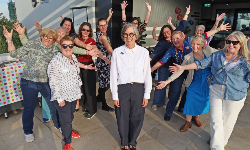 A group of clinicians celebrate a centralised experienced womanfemale on an outdoor terrace