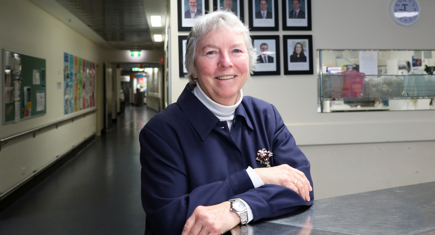 Dr Eileen Burkett standing at admin desk of Ward 1D