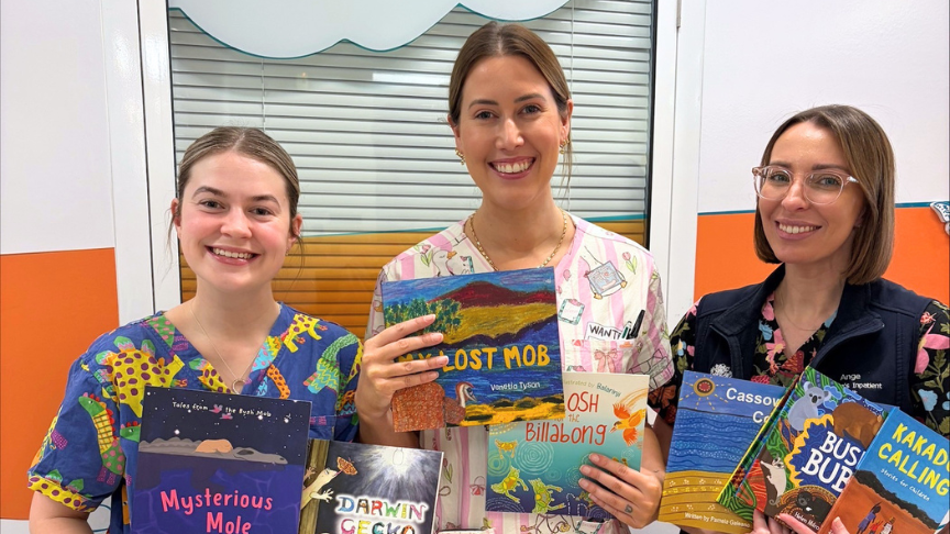 Three nurses colourful scrubs holding First Nations books
