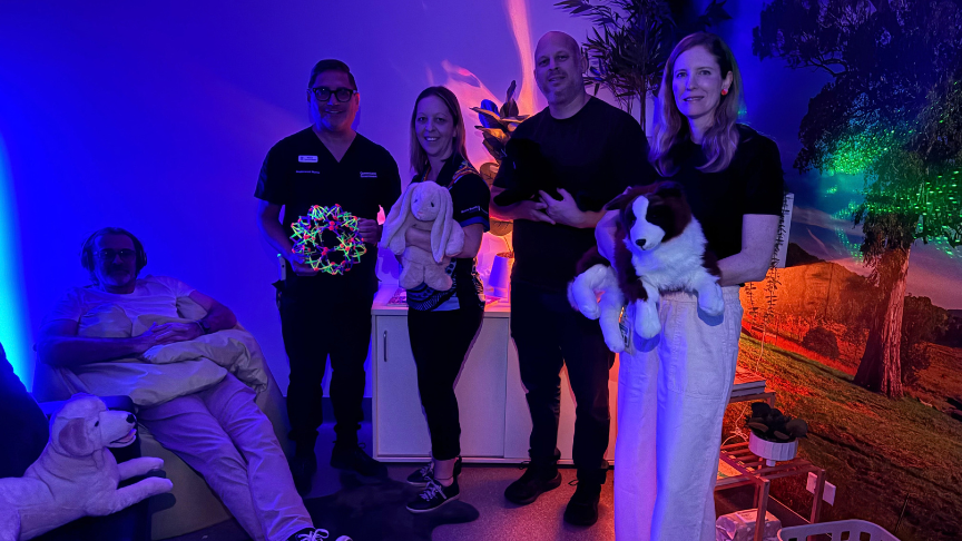 A group of people holding sensory aids in a mood-lit room