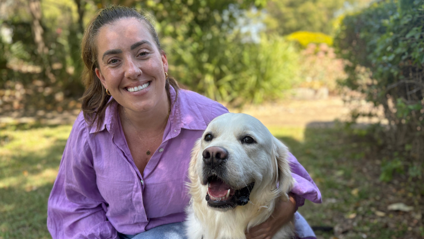Smiling female clinician and large golden retriever