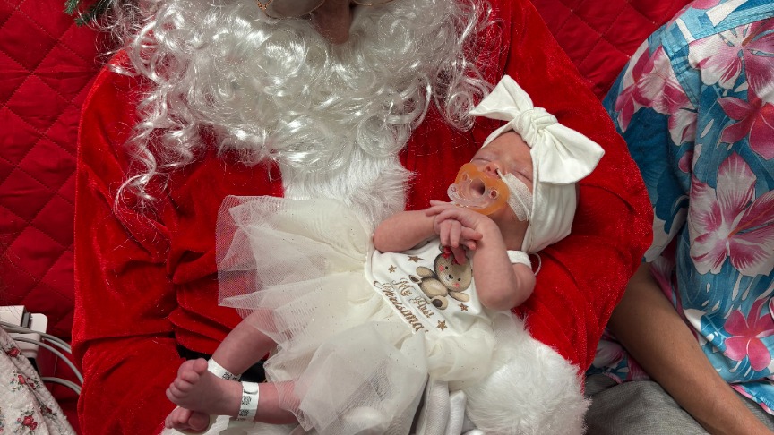 Close up of a baby girl in Santa's arms