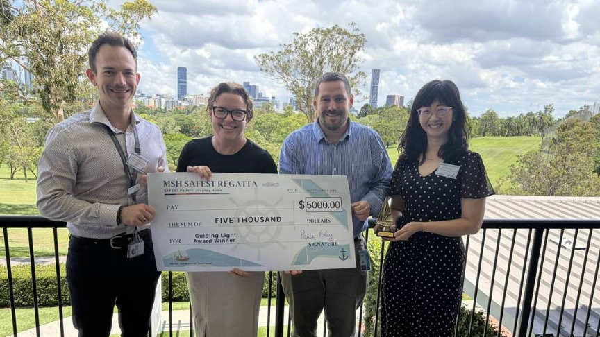 Four individuals proudly display a $5,000 check, celebrating their achievement together.