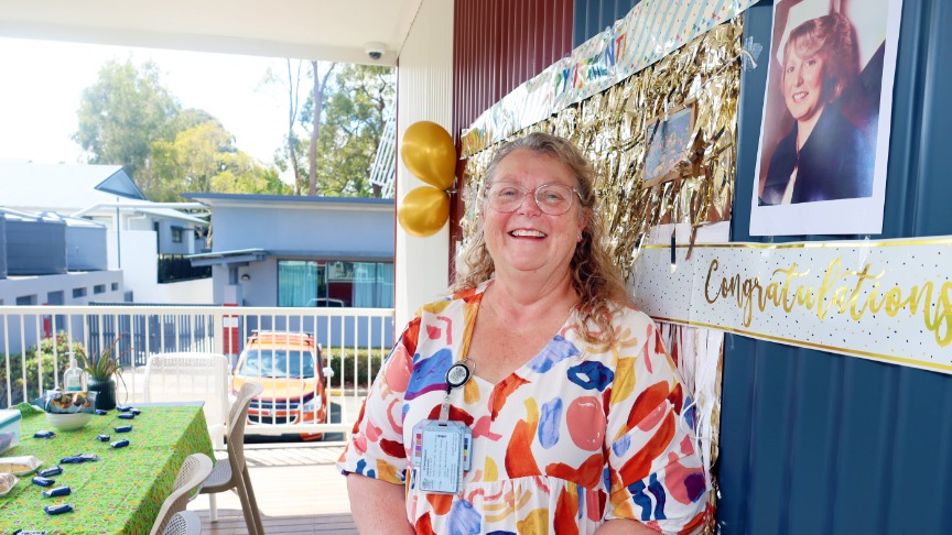 woman standing on deck smiling.