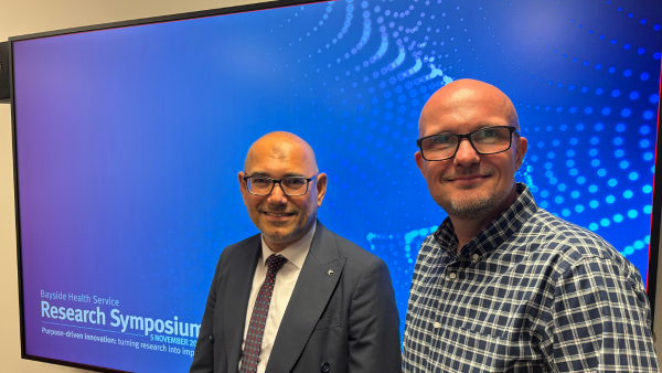Two gentlemen promoting Research Symposium