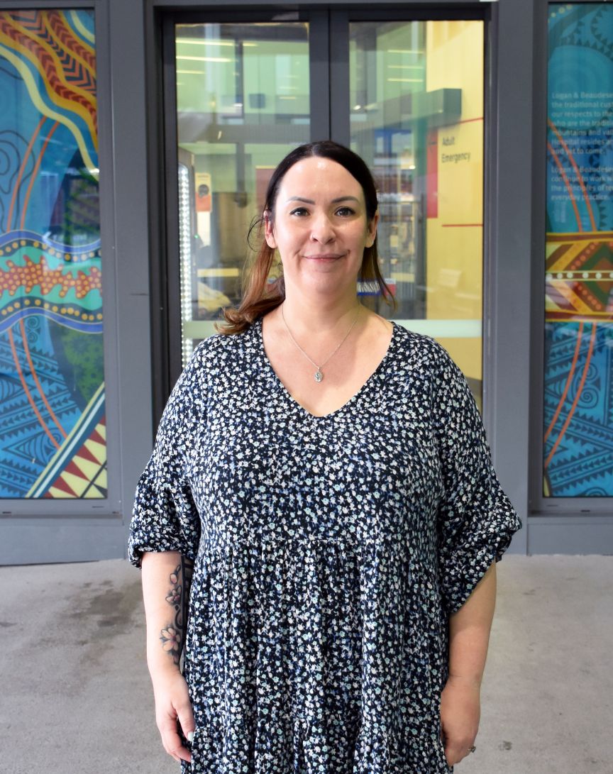 A nurse standing in front of glass doors with First Nations decals