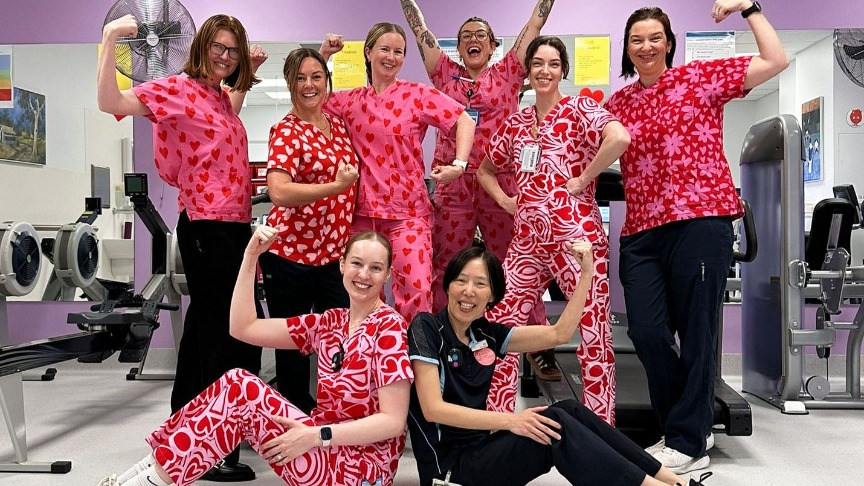 A group of women in pink scrubs smiling together at the Heart Recovery Gym at PA Hospital