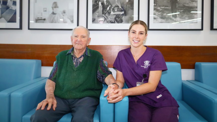 Samantha and her grandfather John sit on a couch holding hands