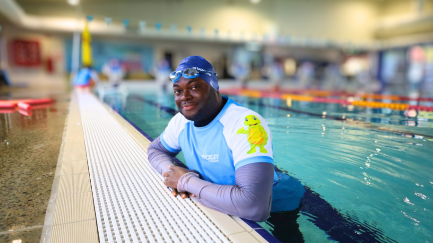 Ben smiling at the camera in a pool