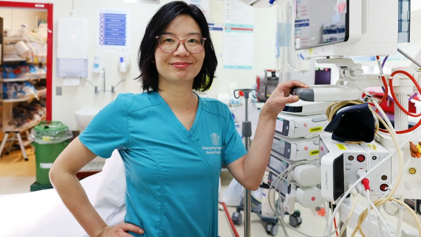 Nurse standing in resus bay at ED smiling