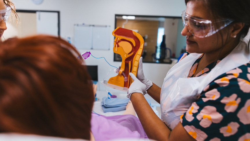 Picture of a Speech Pathologist holding an educational tool