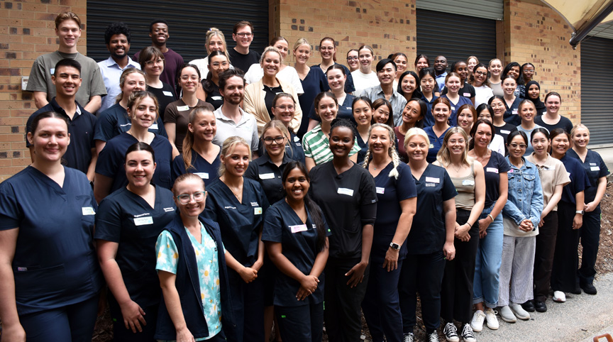 A large group of graduate nurses wearing scrubs