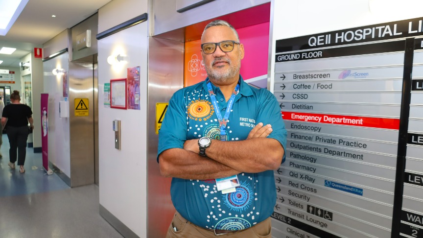 Man standing in front of lifts with arms crossed.