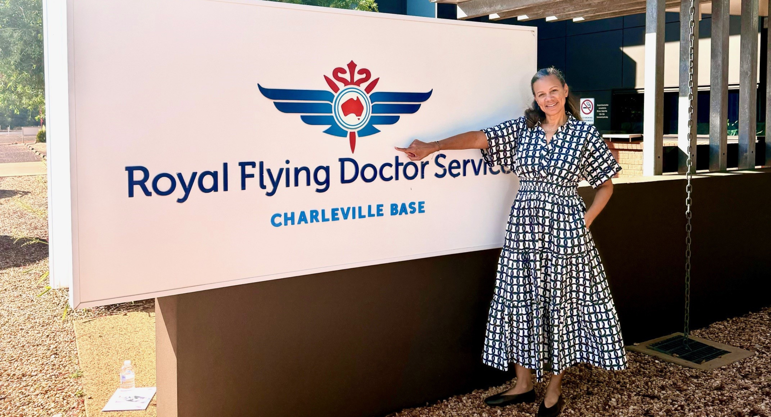 female doctor pointing at Royal Flying Doctor Service sign
