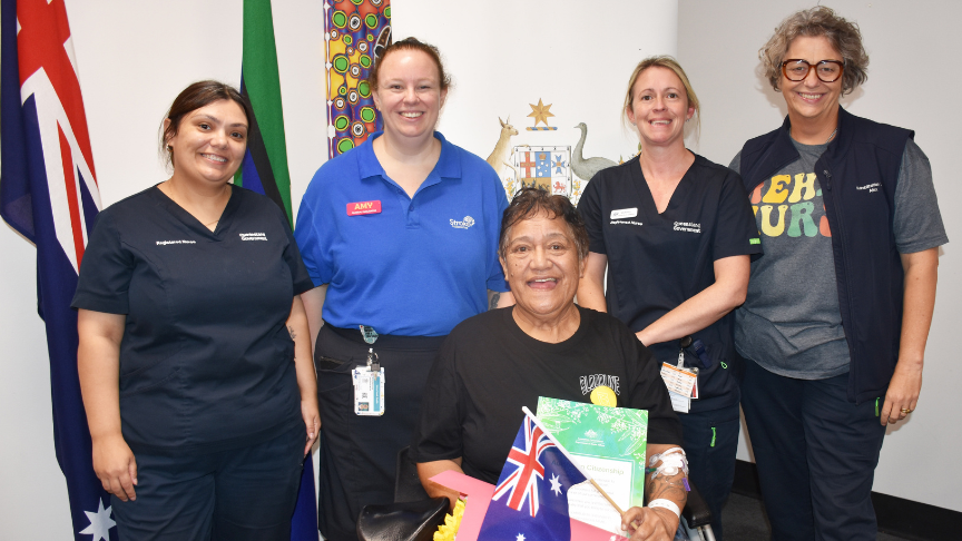 Nurses standing around a woman in a wheelchair