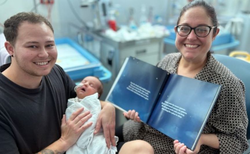 Picture of parents with tiny baby reading