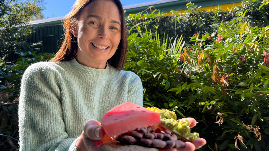 Donni is holding plastic food up to the camera