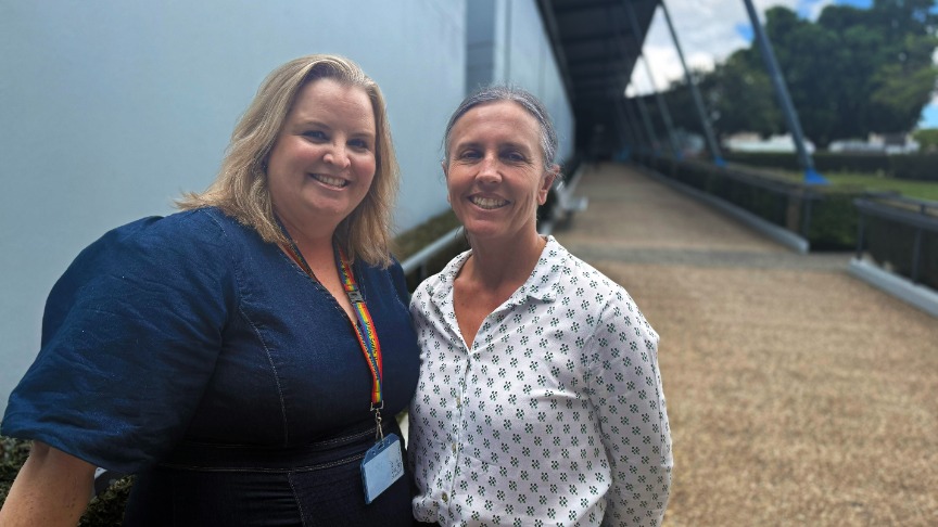 two women standing side by side outside a hospital