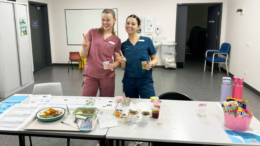 Two young women standing behind a table with various activities on it