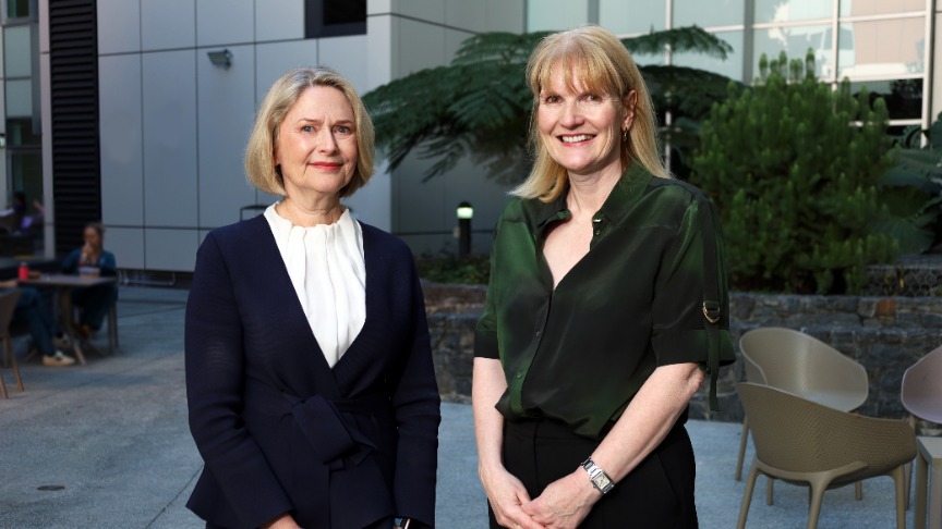 Two women, the Chief Executive of Metro South Health and a Professor of Geriatrics, pose in front of the PA Hospital atrium
