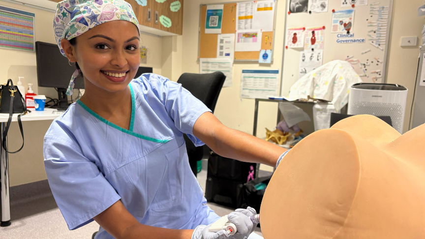 Female doctor posing with VACCA and mannequin