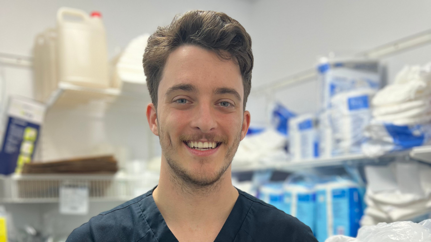 Young male nurse standing in front of medical supplies