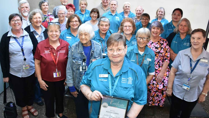 large group of Logan Hospital volunteers standing in a courtyard
