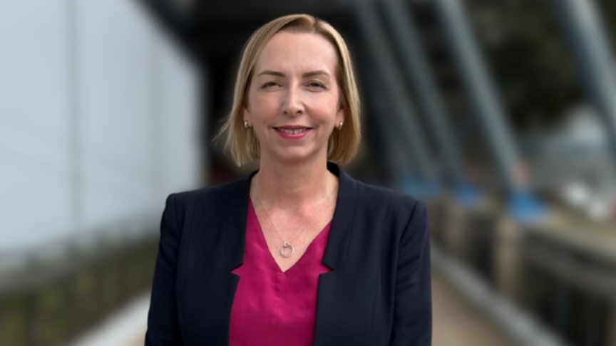 Portrait of a woman with short hair standing in front of a blurred background