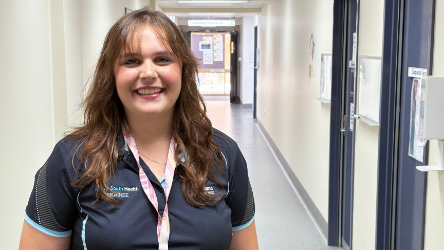 School-aged girl standing in a branded polo shirt in a hallway