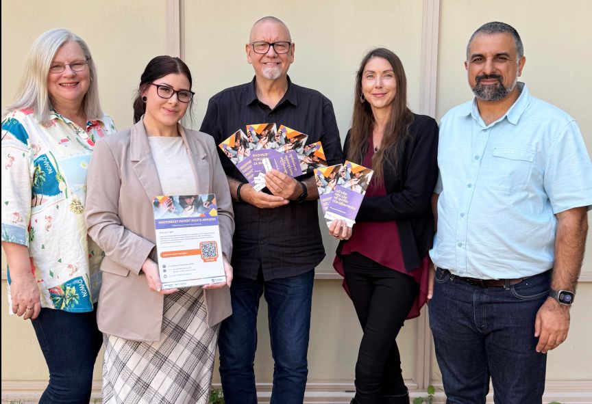 A group of people with some holding translated information brochures
