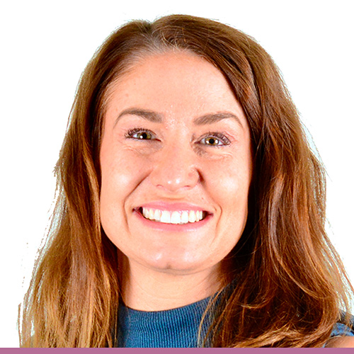 A person wearing a blue top, with shoulder length medium dark hair, against a white background