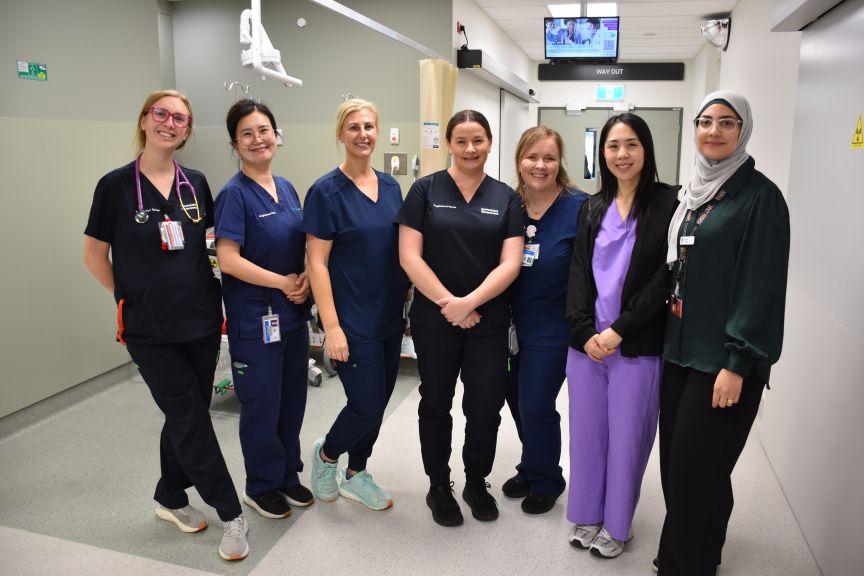 group of nurses standing in a clinical hallway