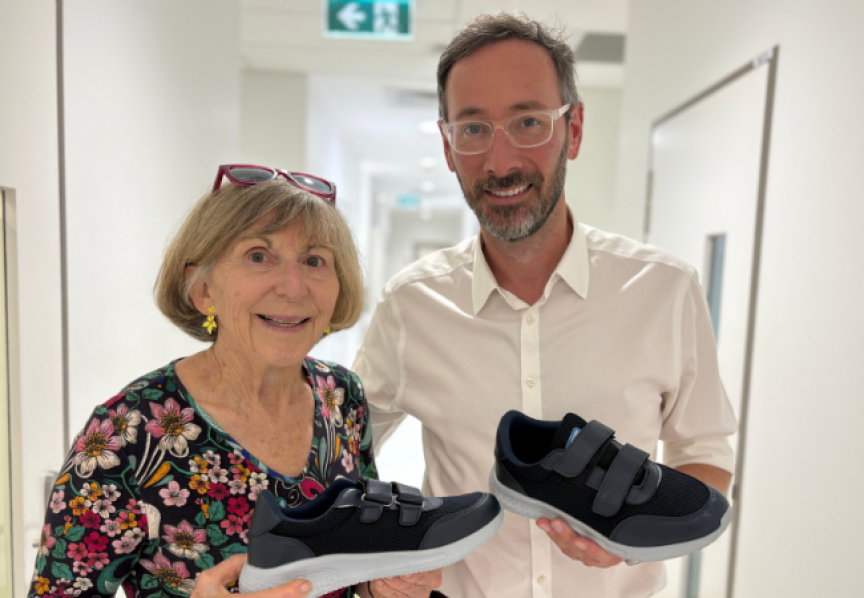 Doctor and patient smiling and holding up smart shoes
