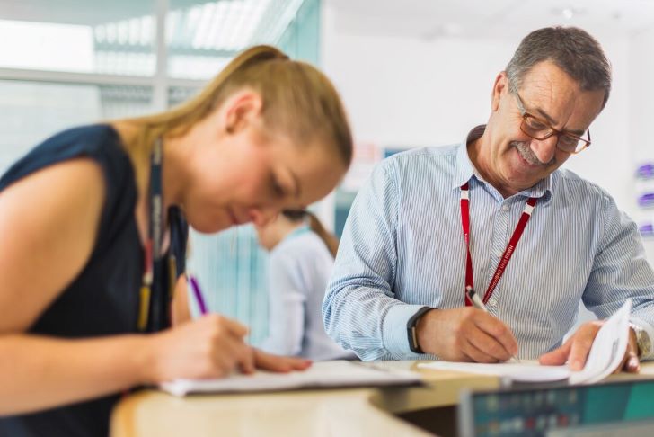 Two people signing documents