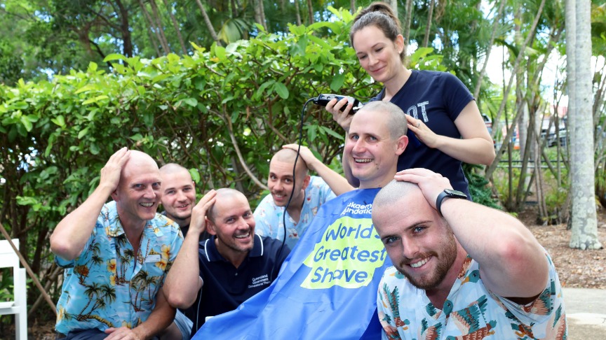Occupational therapists surround a seated man, participating in the Shave for a Cure event at PA Hospital