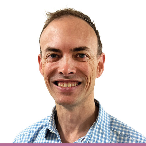 A person in a checkered shirt, with short dark hair, against a white background.
