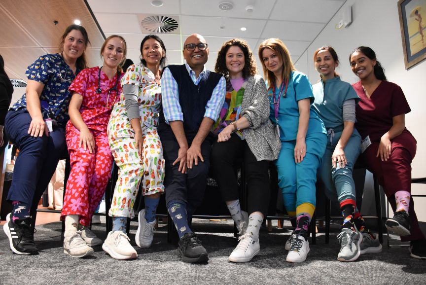 A group of people with their feet forward to show off crazy socks