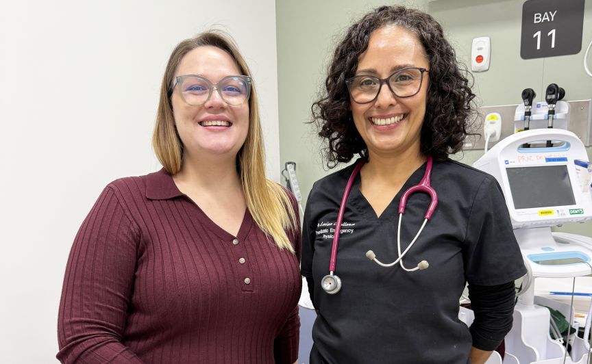 Two women standing in a clinical space, one has a stethascope around her neck