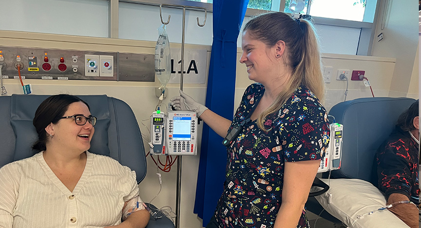 A healthcare worker adjusts an IV drip for a patient in a medical facility.