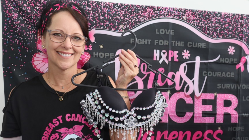 Woman posing with decorated bra on coat hanger