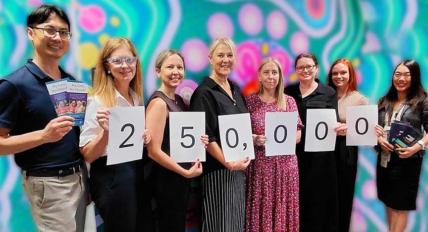Group of people smiling and standing in front of a colourful background holding up a sign with the number 250,000