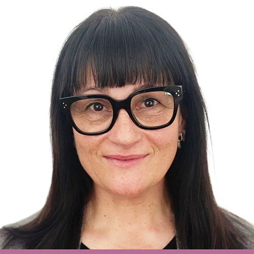 A head and shoulders picture of a women in a black shirt, with black rimmed glasses and shoulder length dark hair, against a white background.