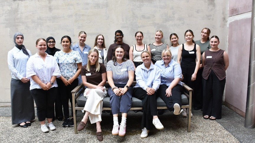 large group of women standing and sitting in a courtyardac