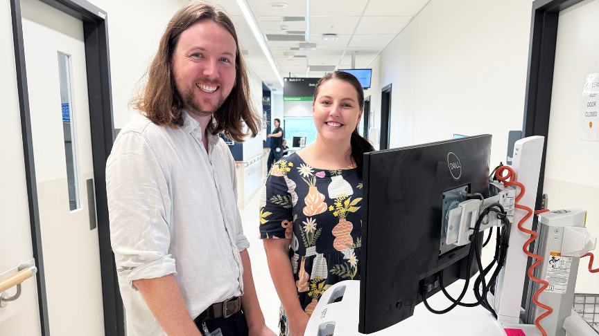 Headshot of a Male and female standing with a computer 