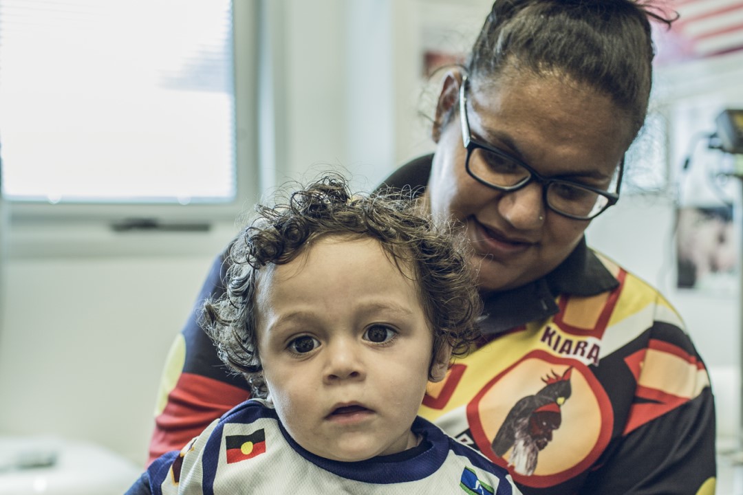 First Nations mother holdFirst Nations mother holding her child in a health clinic.ing her child in a health clinic.