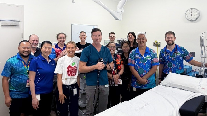 A group of Queensland Health staff gathered around a hospital bed in Cooktown to celebrate the new endoscopy service
