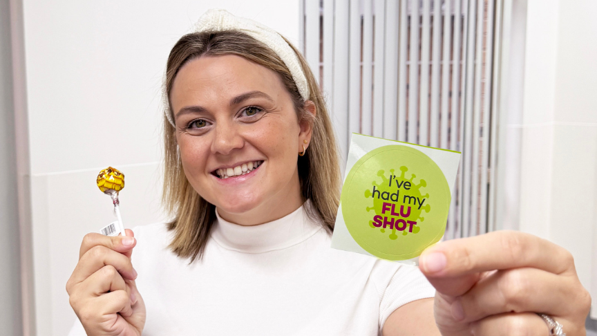 woman holding sticker and lollipop toward the camera